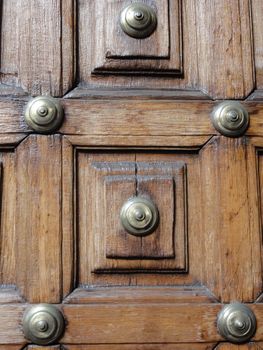 close up photo of a wooden door with brass studs