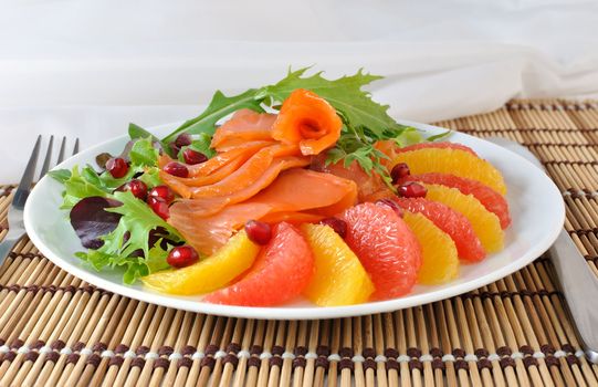 Appetizer of salmon with orange and grapefruit and a mixture of lettuce