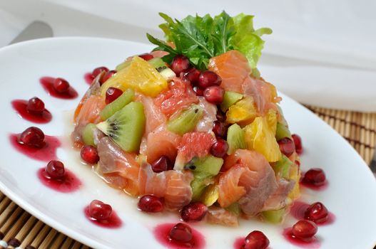 Salad with salmon of different fruits and pomegranate