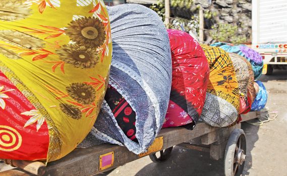 colorful bales of laundry on a handcraft pulled by human power normal scene in Bombay