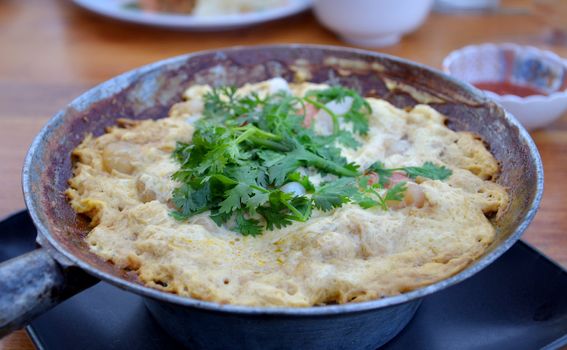 Egg omelet and shrimp in a frying pan
