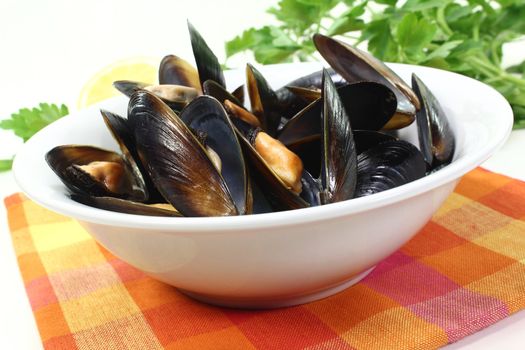 fresh steamed mussels in a white bowl with napkin