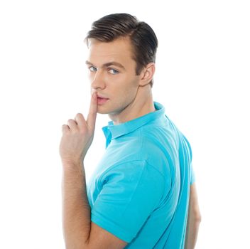 Side view of smart handsome guy gesturing silence isolated over white