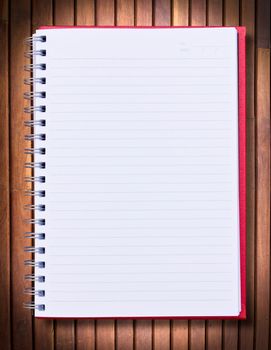 red notebook on wood background