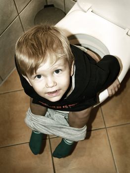 little boy is sitting on the toilet