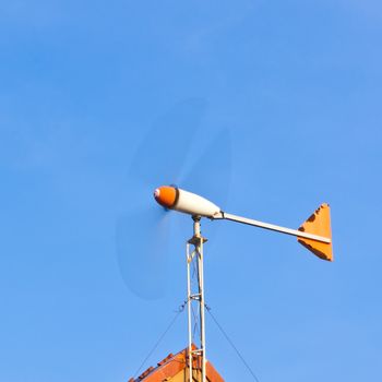 wind turbine on the roof against blue sky