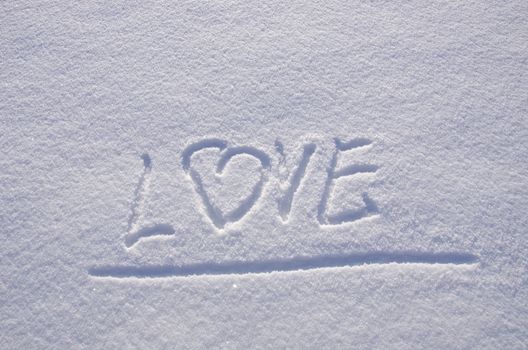 Inscription love on snow in winter. Concept expression of human feelings.