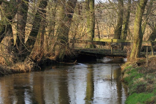 Old bridge over a small river in winter