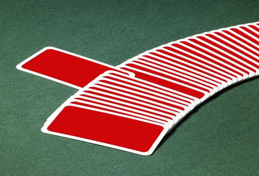 studio photography of spread out playing cards with one chosen, located on green felt