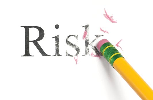 Close up of a yellow pencil erasing the word, 'Risk.' Isolated on white.