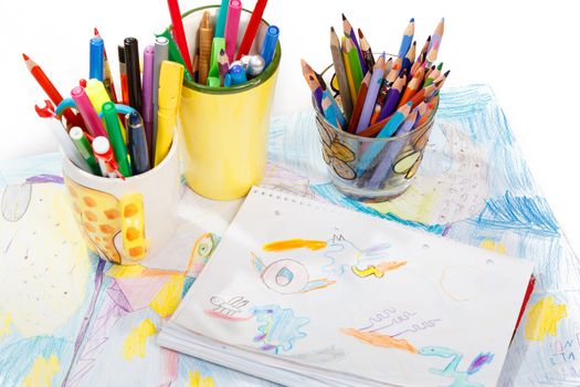 Abstract painting  and pen holders  with colored pens on a white background 