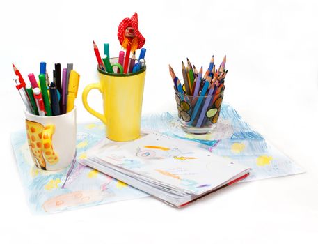 Abstract painting  and pen holders  with colored pens on a white background 