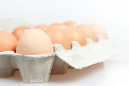 Fresh eggs in carton box on white background