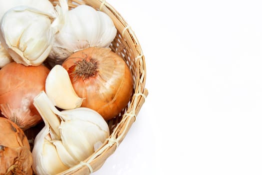 Onion and garlic clove in basket isolated on white background 