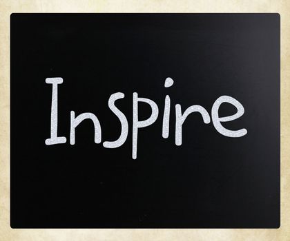 "Inspire" handwritten with white chalk on a blackboard