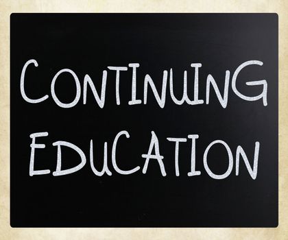 "Continuing Education" handwritten with white chalk on a blackboard
