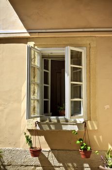 old opened window with flowerpots