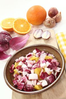 Chicory salad with a bowl of shallots and orange