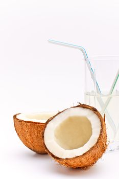 halves of coconut and glass with coco milk