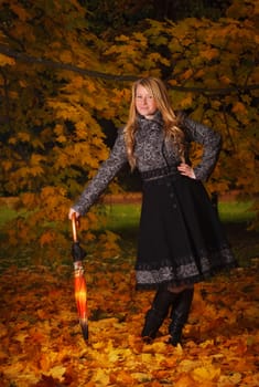 beautiful girl with umbrella in autumn forest