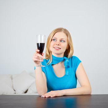 beautiful woman sitting at table drinking wine