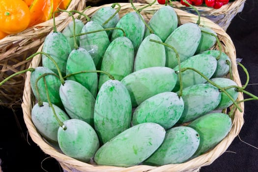 green mango in bamboo basket