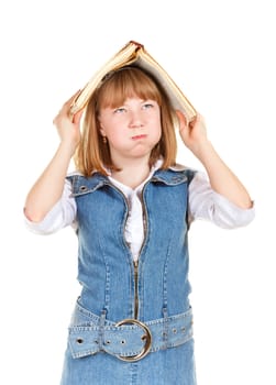 angry schoolgirl with book on her head, isolated on white