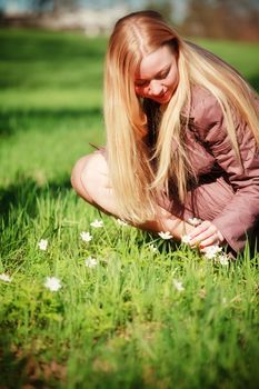 beautiful woman picking flowers in spring park