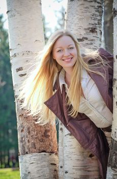 beautiful smiling blond woman in birch park