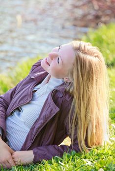 beautiful blond woman laying on river bank