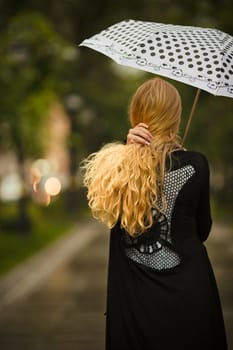 girl with white umbrella walking under the rain