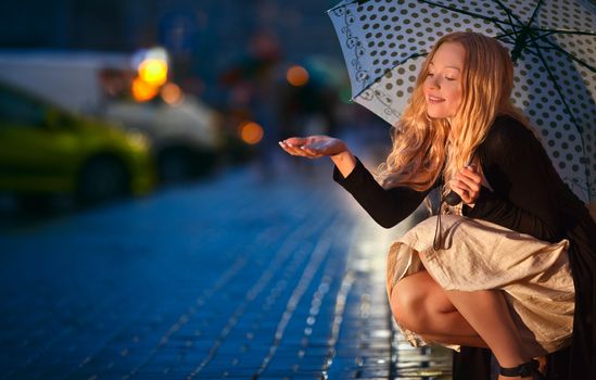 girl with umbrella on street at night