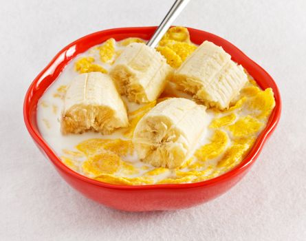 cornflakes with banana in bowl on table