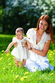 Happy mother and daughter on the green grass