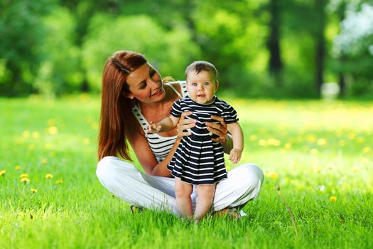 Happy mother and daughter on the green grass