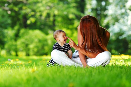 Happy mother and daughter on the green grass