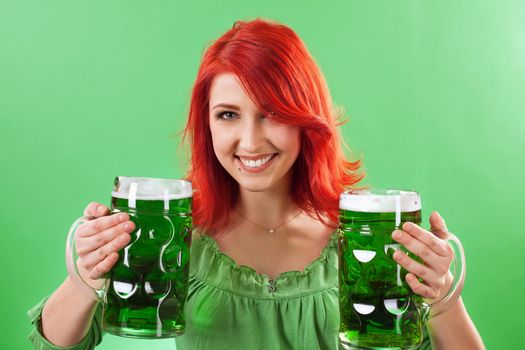 Photo of a beautiful redhead holding two huge mugs of green beer for St. Patricks Day celebrations.