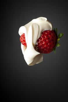 Whipped creme and red strawberry isolated on gray side lighting