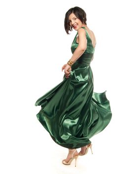 Young woman spinning in a green dress isolated on white