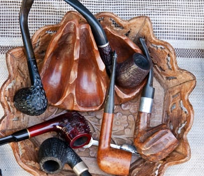 several different smoking pipes - made of wood