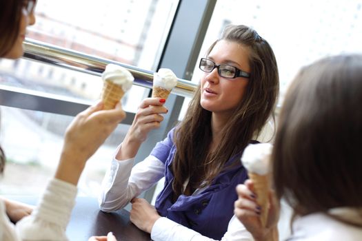 women on foreground licking ice cream 