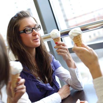 women on foreground licking ice cream 