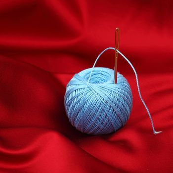 thread on red silk isolated close up