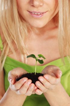 plant in blonde hands close up