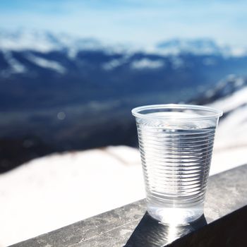 water in cup mountains on background