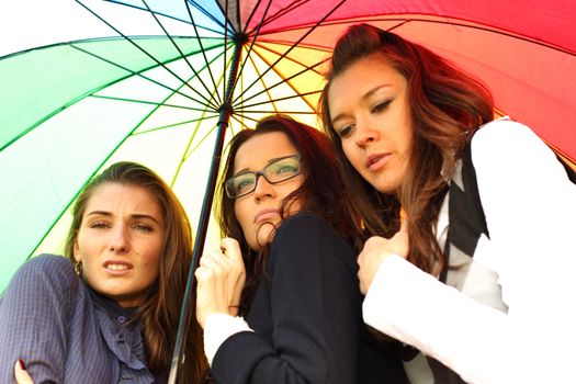 girlfriends stay under colourful umbrella 