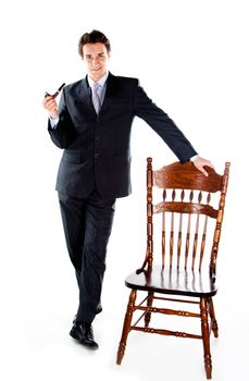 Portrait of a young handsome man in a dark suit with a strict smoking a pipe in his hand