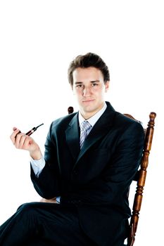 Portrait of a young handsome man in a dark suit with a strict smoking a pipe in his hand