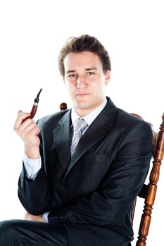 Portrait of a young handsome man in a dark suit with a strict smoking a pipe in his hand