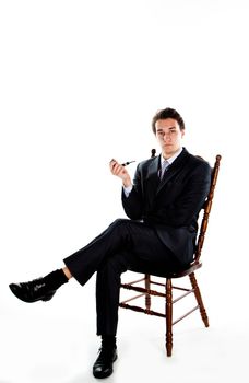 Portrait of a young handsome man in a dark suit with a strict smoking a pipe in his hand